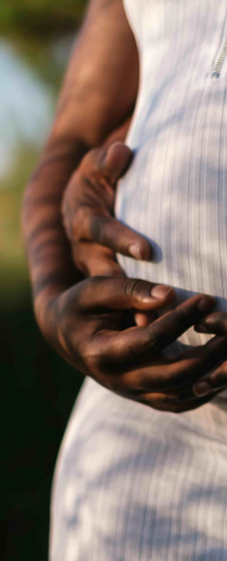 Maternity leave and pay | Hands of a pregnant woman and her partner embracing her belly