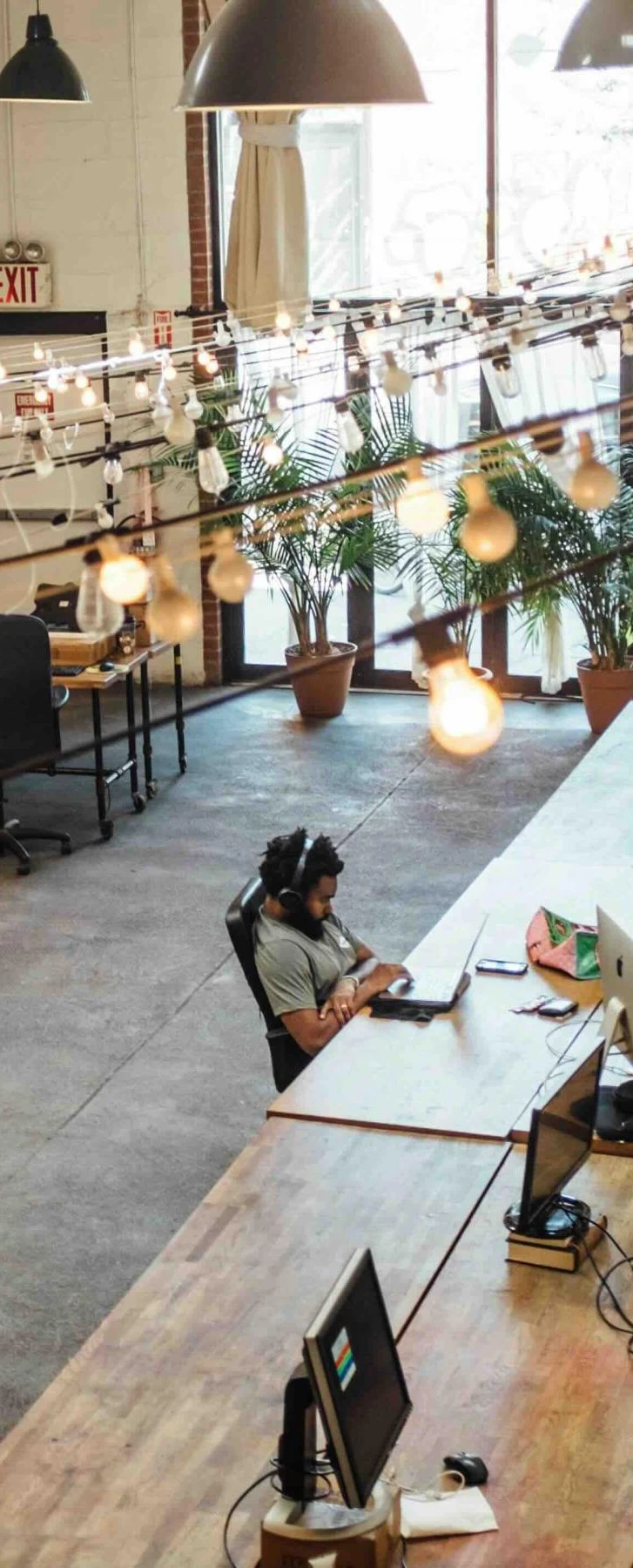 Man at communal desk in large office space | How to get a promotion